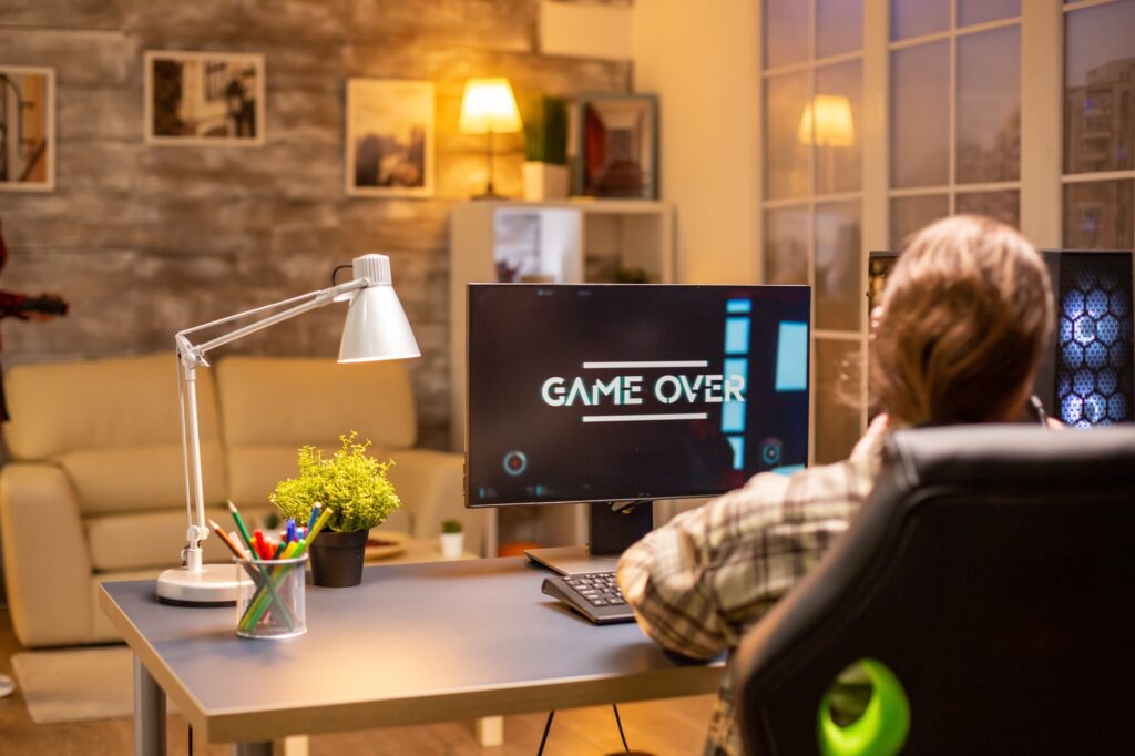Professional male gamer playing on powerful PC and losing the game